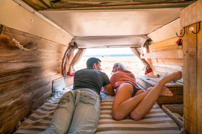 truck camper shell clamps holding interior with caucasian couple of traveler parked in front of the ocean to enjoy freedom and different tiny house for the couple. enjoy lifestyle in summer