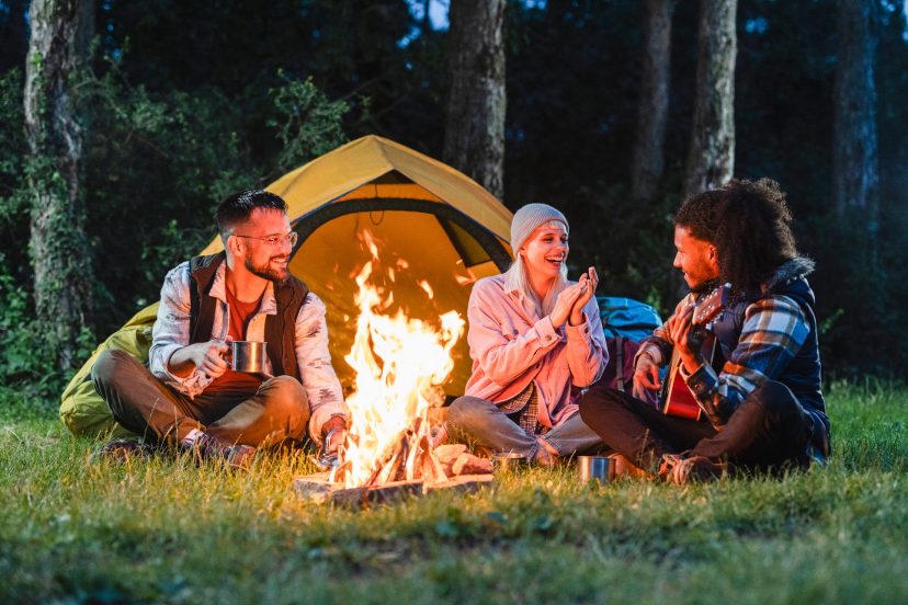 Friends enjoying a campfire and music during a camping trip