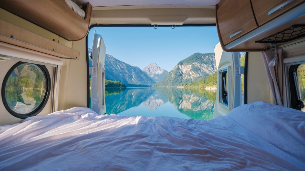 Embracing nature beauty from a cozy camper van in Plansee, Austria on a bright morning