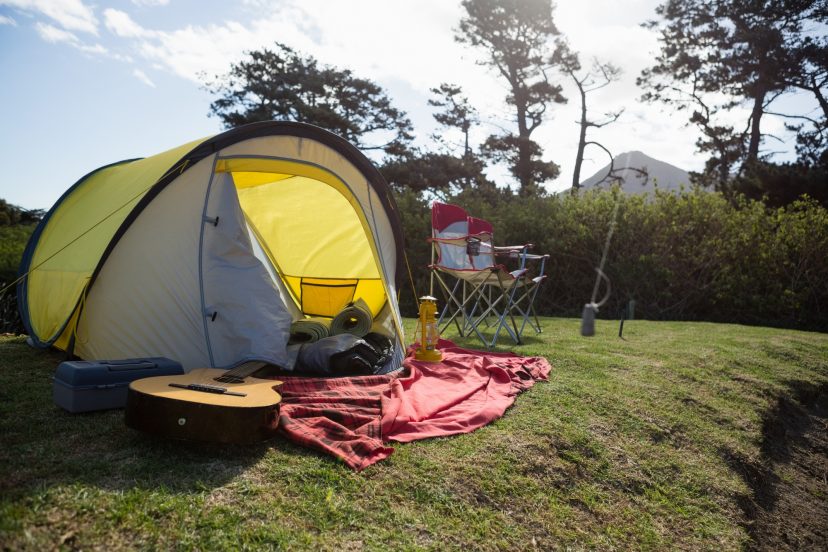 Empty tent and guitar in the park